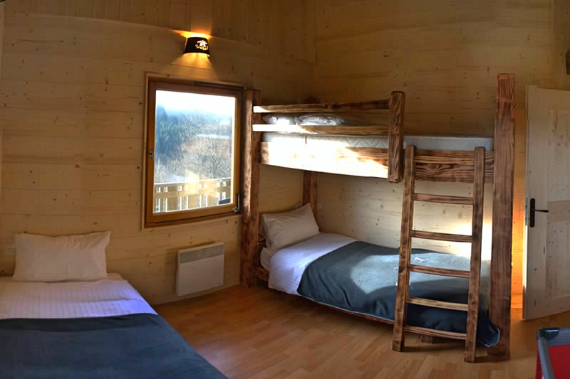 The Tremplin bedroom, with a bunk bed as well as a single bed, and including a view over the Bas-Rupts’ ski jump